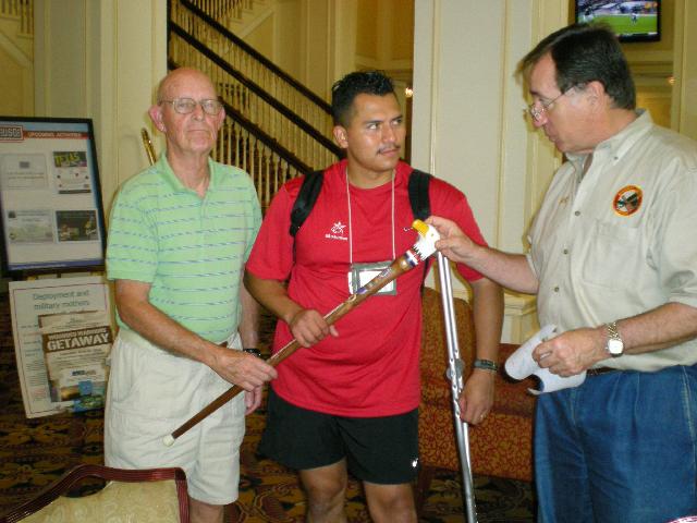 Army Sgt Luis Gamarra. Cane carved by Art Keys of MHWG. Presentation by Col Sniffen (left) & Col Connors (right).